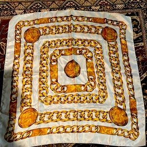 Scarf. 34” x 34”. 100% polyester. Gold link pattern.